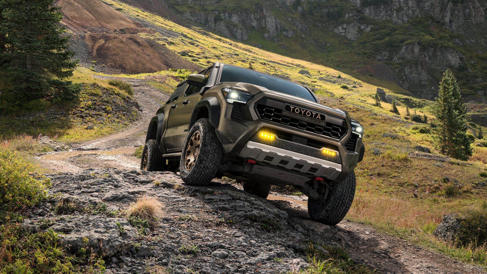 2025 Toyota Tacoma Tacoma driving on dirt road across hillside