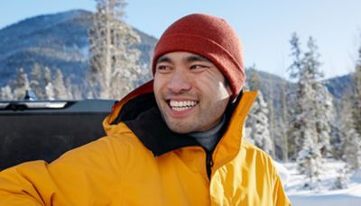 Man in a yellow jacket smiles at the camera.