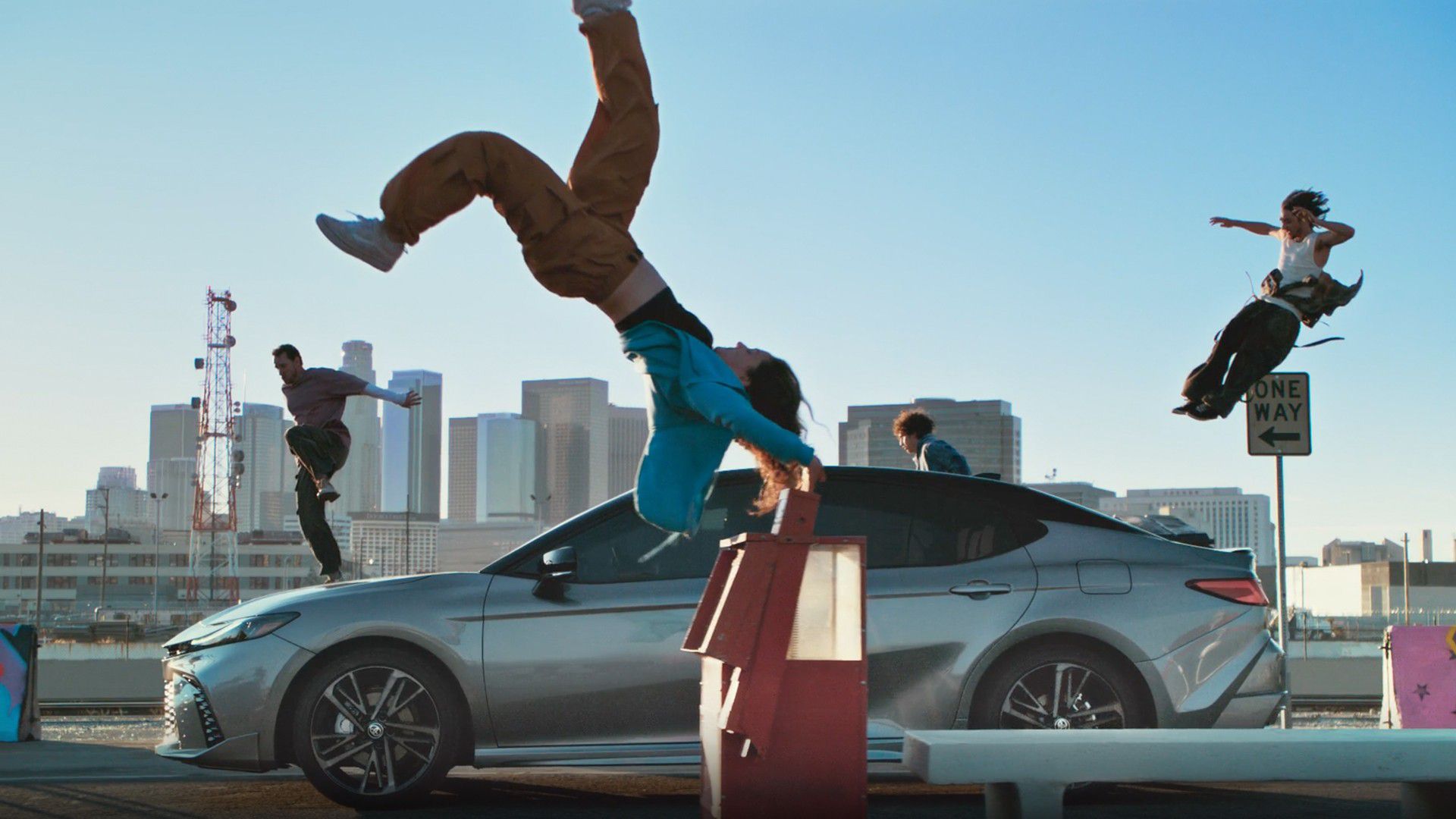 An image of people dancing outside of a vehicle and jumping in the air.