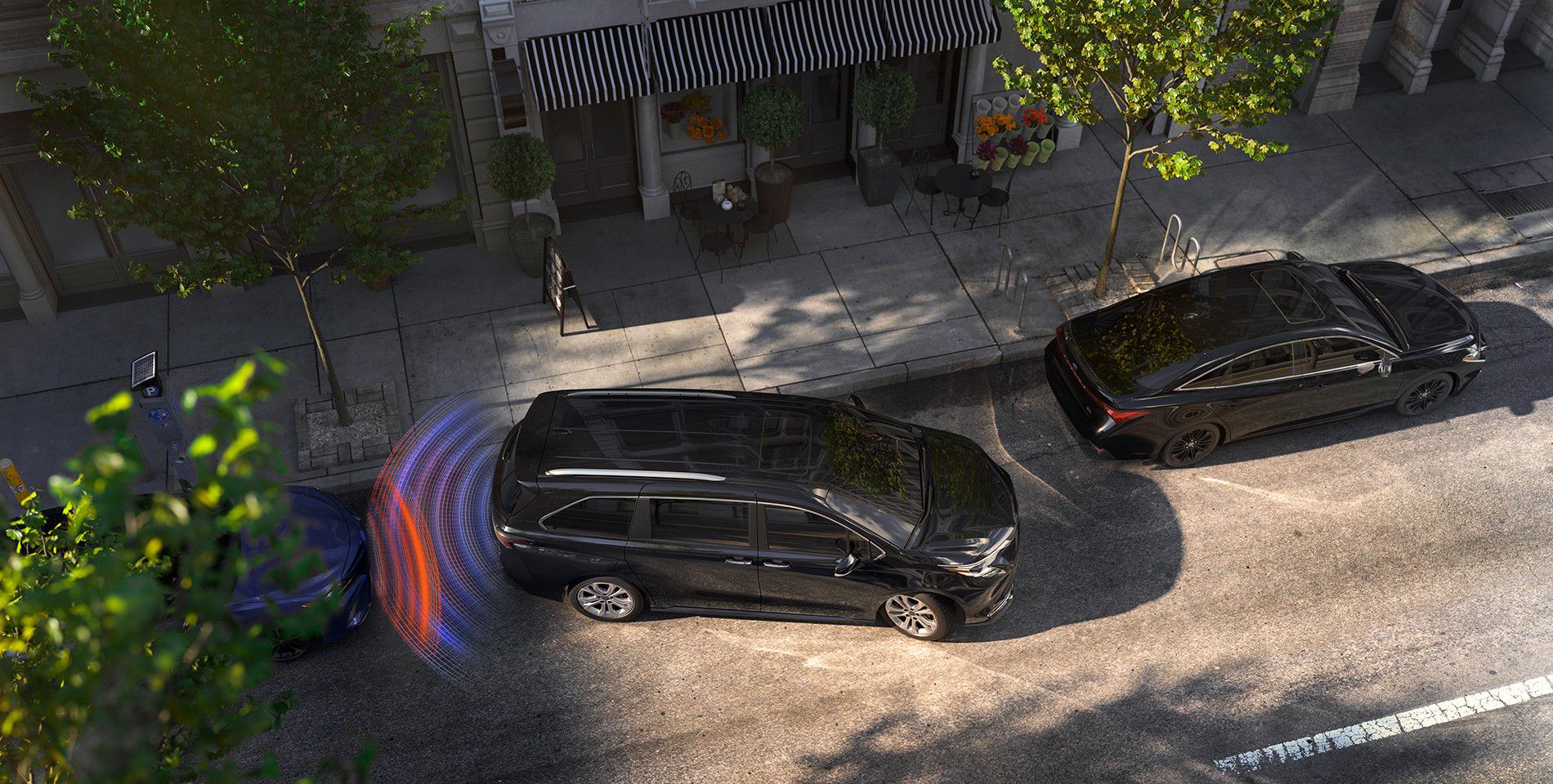 An overhead image of black Toyota vehicle parallel parking on a city street with the parking assist system lights seen at the back of the vehicle.