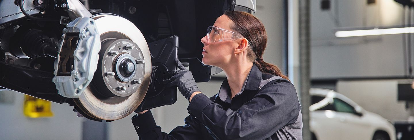 Lexus technician completing work on a Lexus model's brakes
