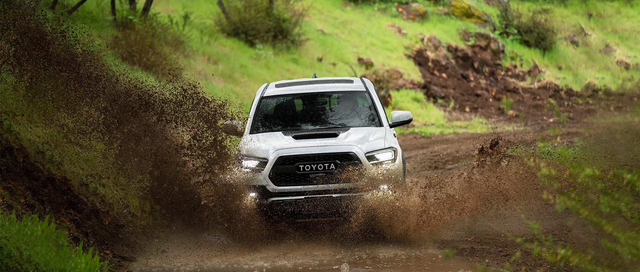 A Tacoma driving through mud.
