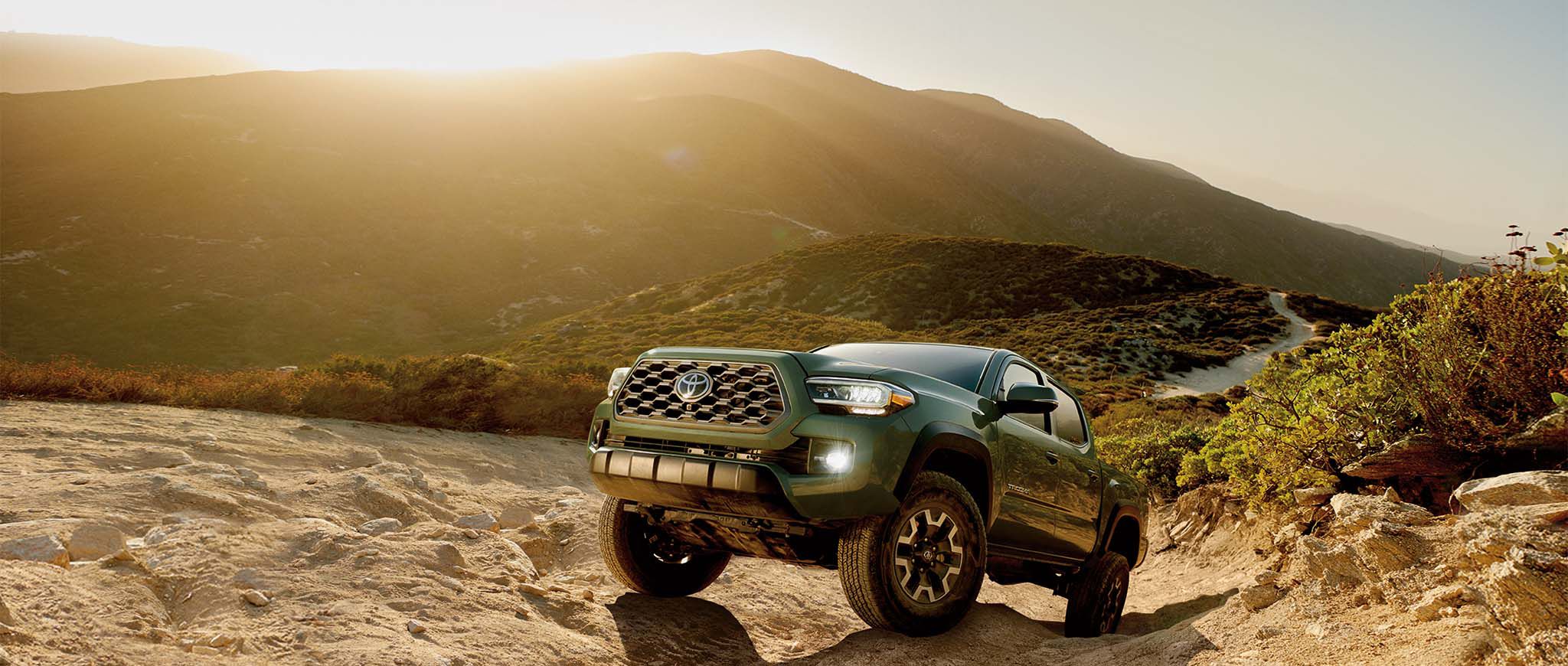 A Tacoma parked by mountains.