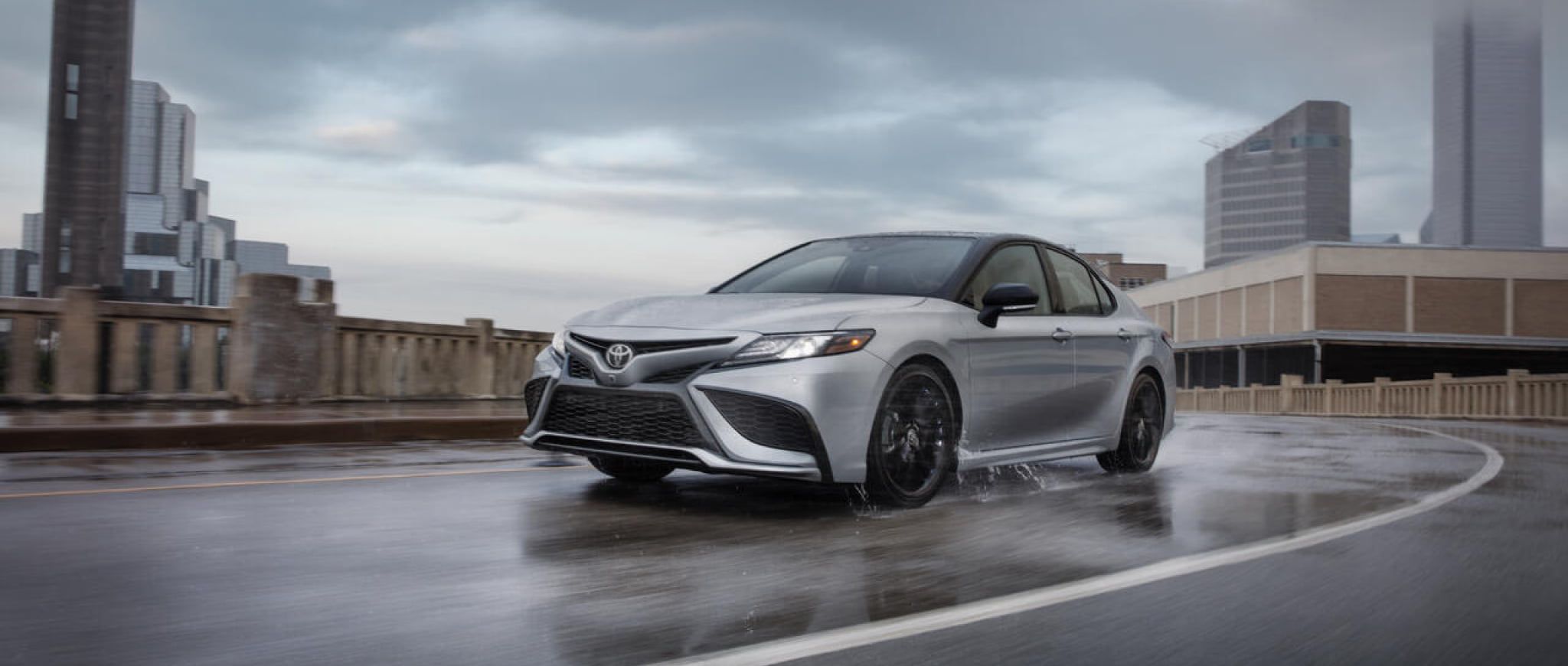 A 2022 Toyota Camry XSE AWD driving on a rain-covered street. 