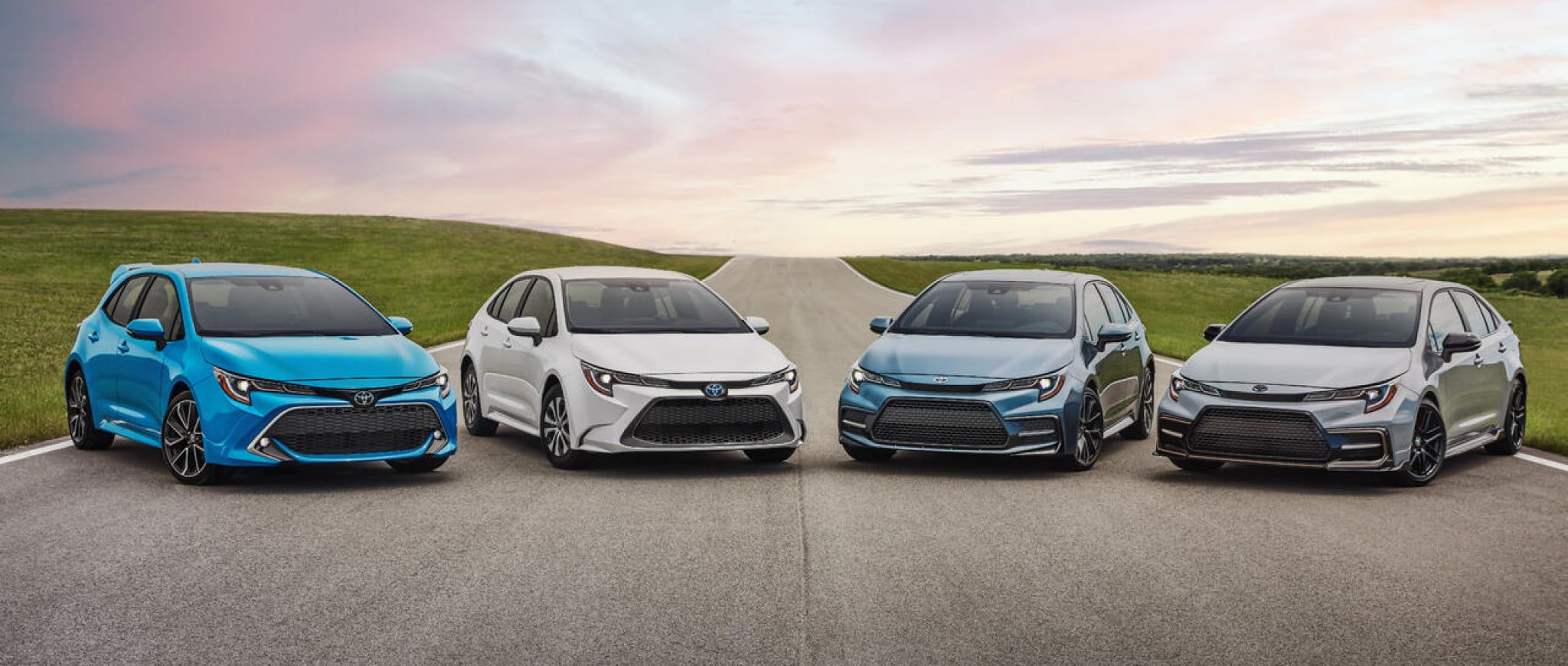A Blue Flame 2022 Toyota Corolla Hatchback  alongside three other Toyota Corollas shimmering in the light of a beautiful sunset.