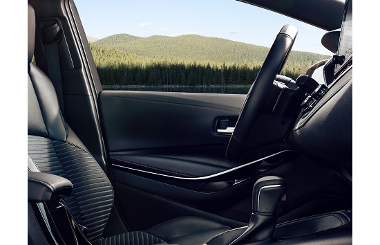 2023 Toyota Corolla XSE interior shown with a view of a forested mountaintop out of the driver side window.