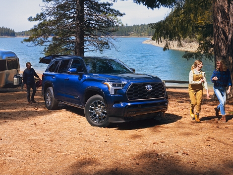 Una Toyota Sequoia 2023 en el color Blueprint en un área para acampar junto al lago.