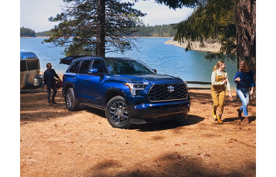 A 2023 Toyota Sequoia in the color Blueprint at a lakeside camping spot.