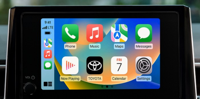 Set against a blurred greenish backgroud, the 8.0-inch display of the 2023 Toyota Corolla is seen with several menu options and the Toyota app on the screen. 
