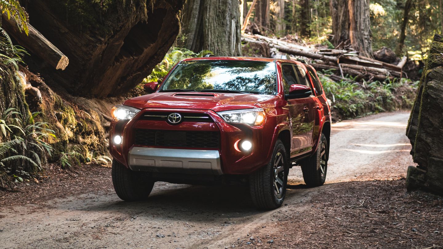 Barcelona Red Metallic exterior Toyota 4 Runner Limited trim dirving into large forrest