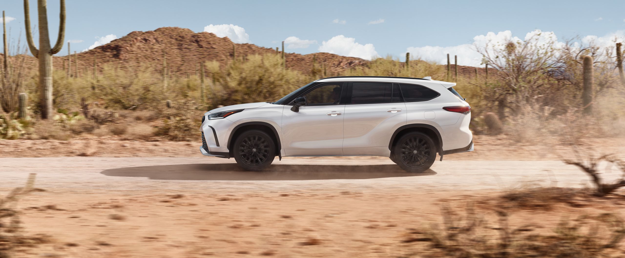 a white suv driving in the desert