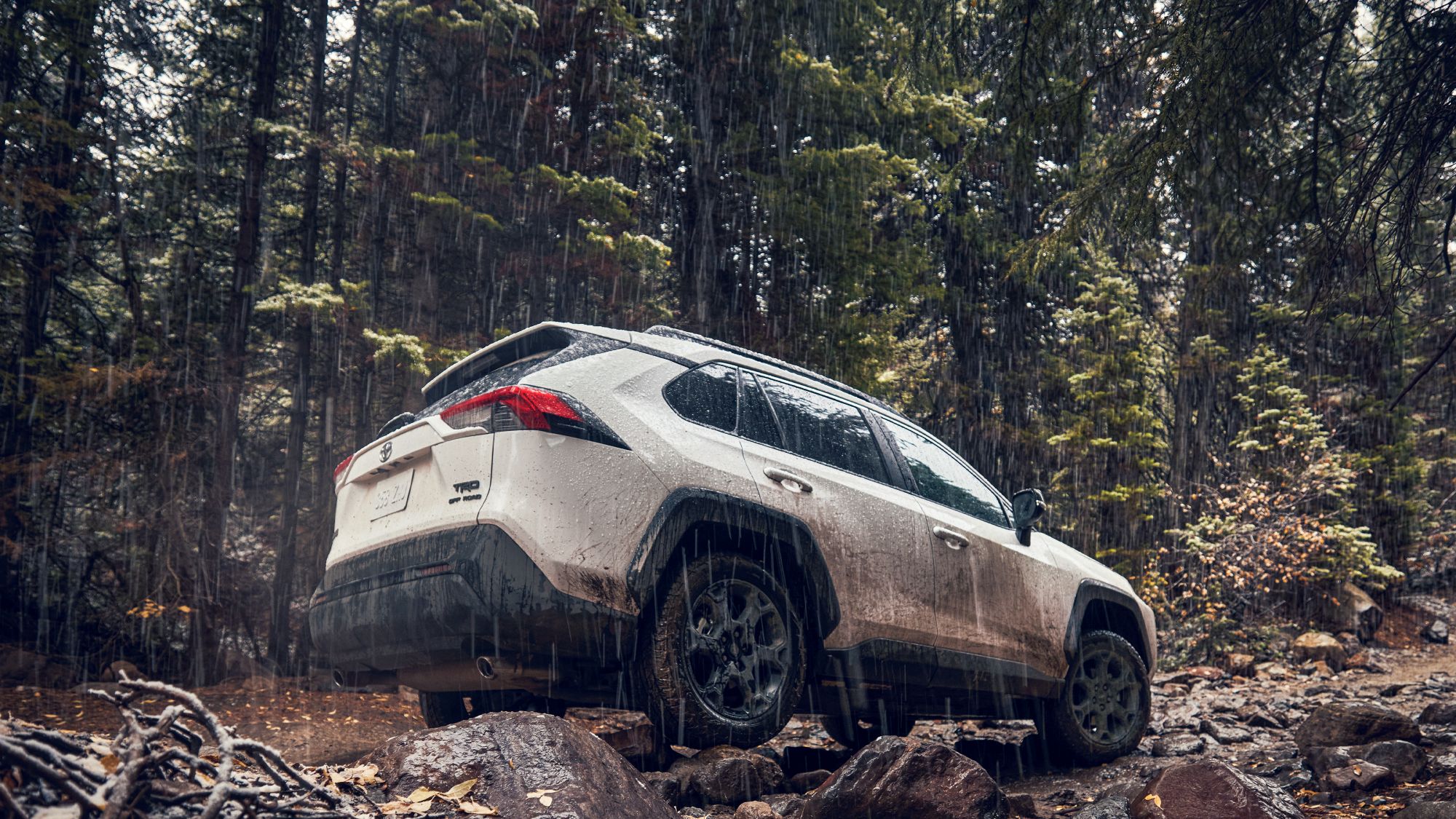 a rav4 driving off road in the rain