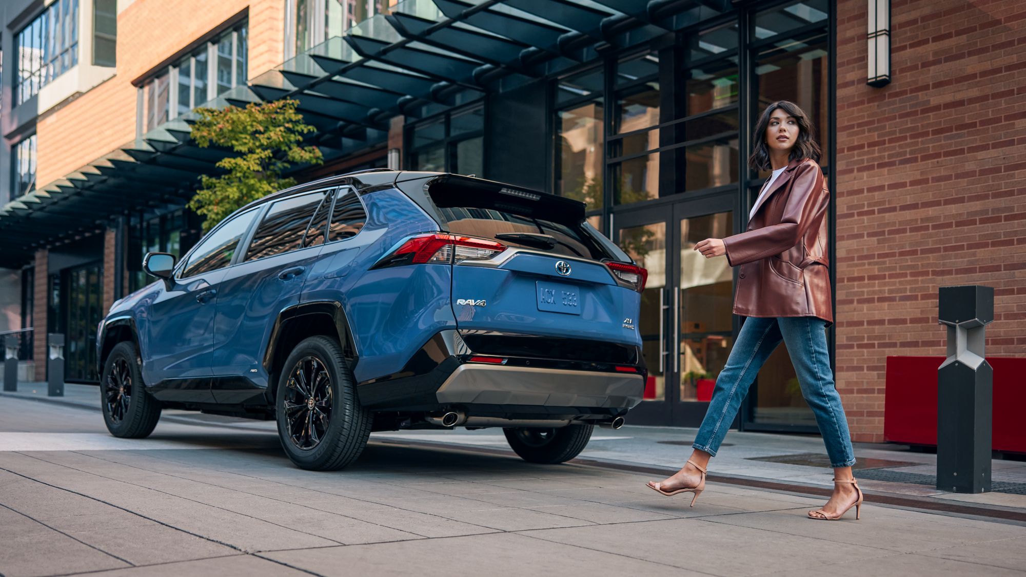 a woman walking towards a rav4