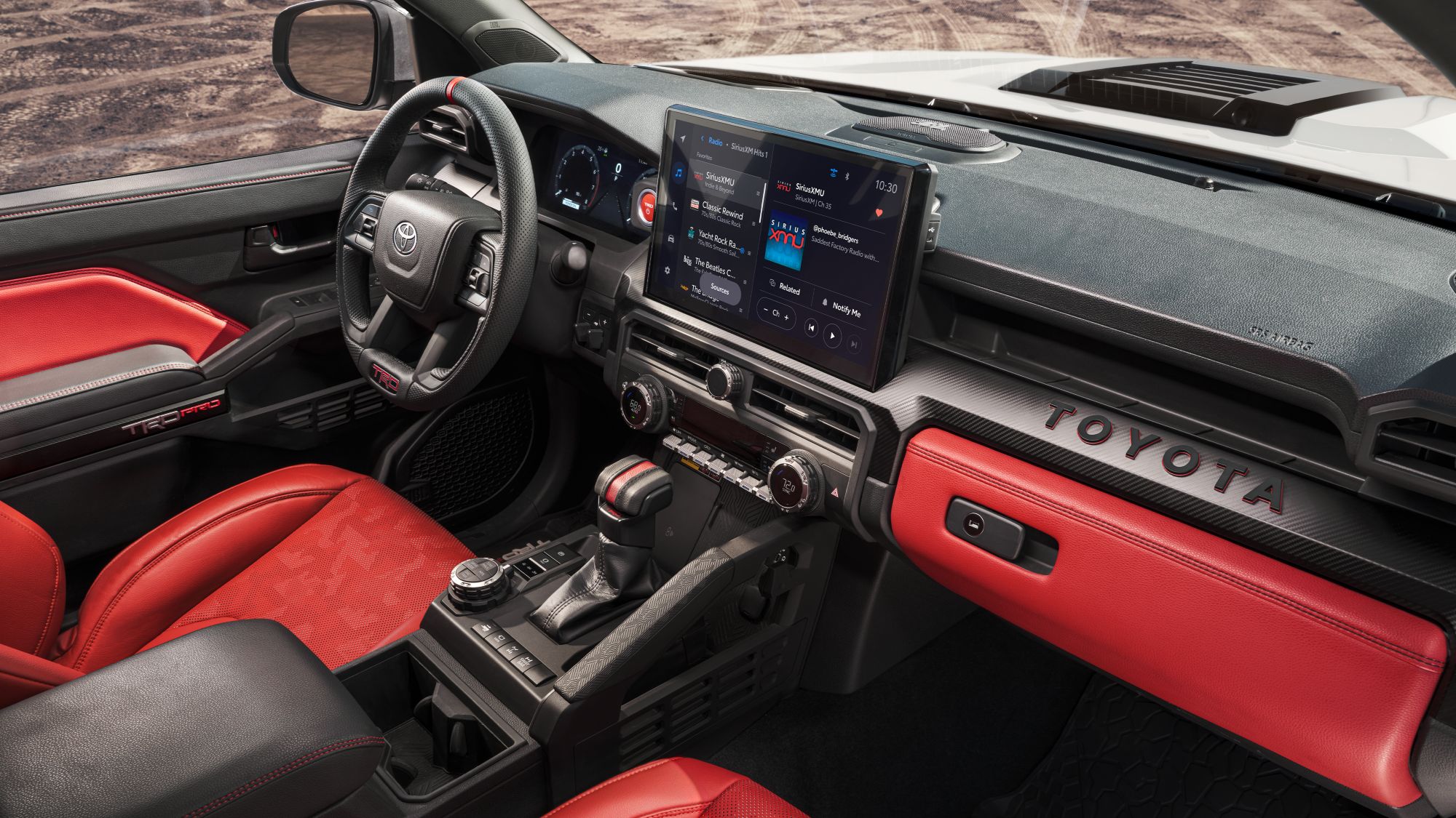 Toyota Tacoma front seat row TRD carbon fiber accents with red interior and JBL speakers on the dash
