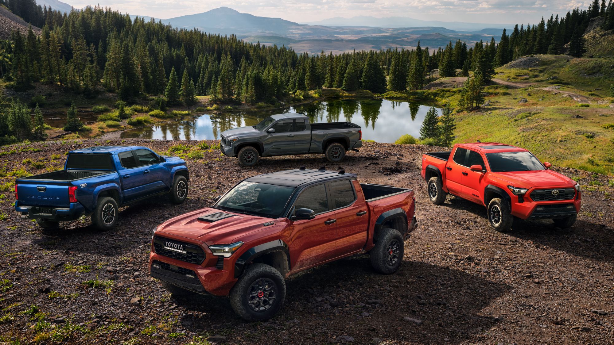 Toyota Tacoma Trailhunter, TRD Pro, Sport, and i-FORCE MAX parked around a lake in a circle formation