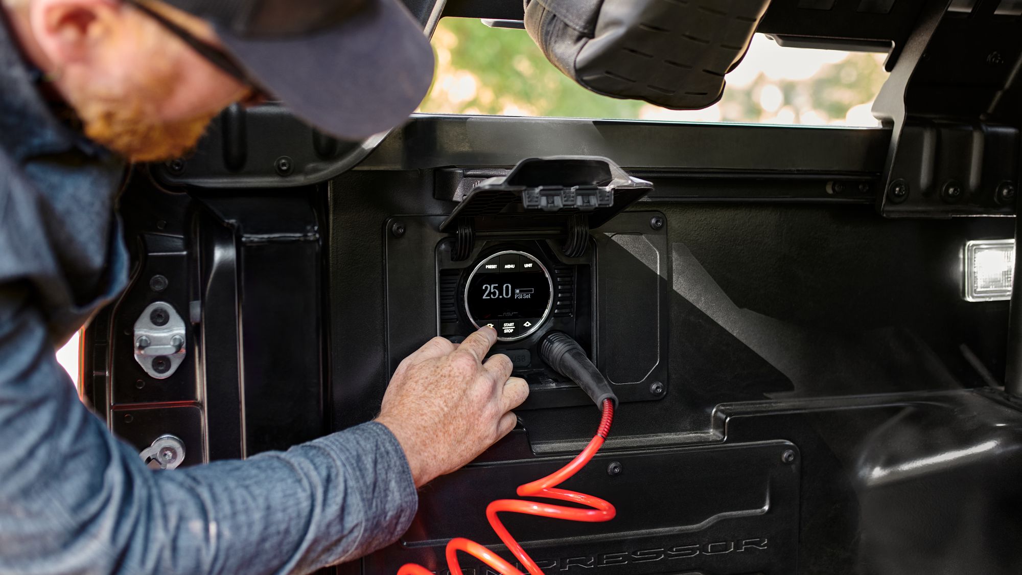 Toyota Tacoma open truck bed with man plugging generator into the 15amp 120 volt electrical receptacle