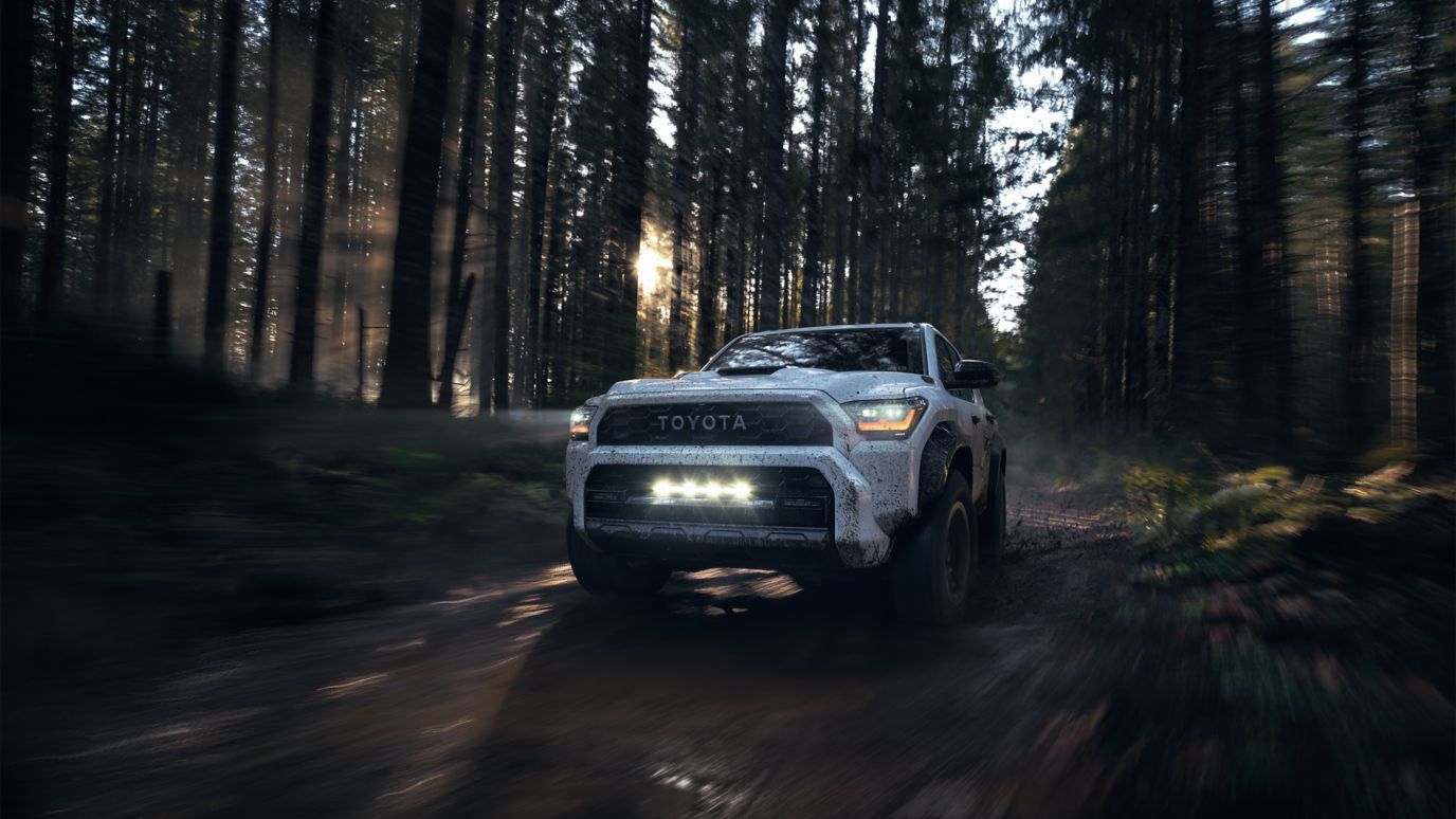 A silver suv on a dirt road.
