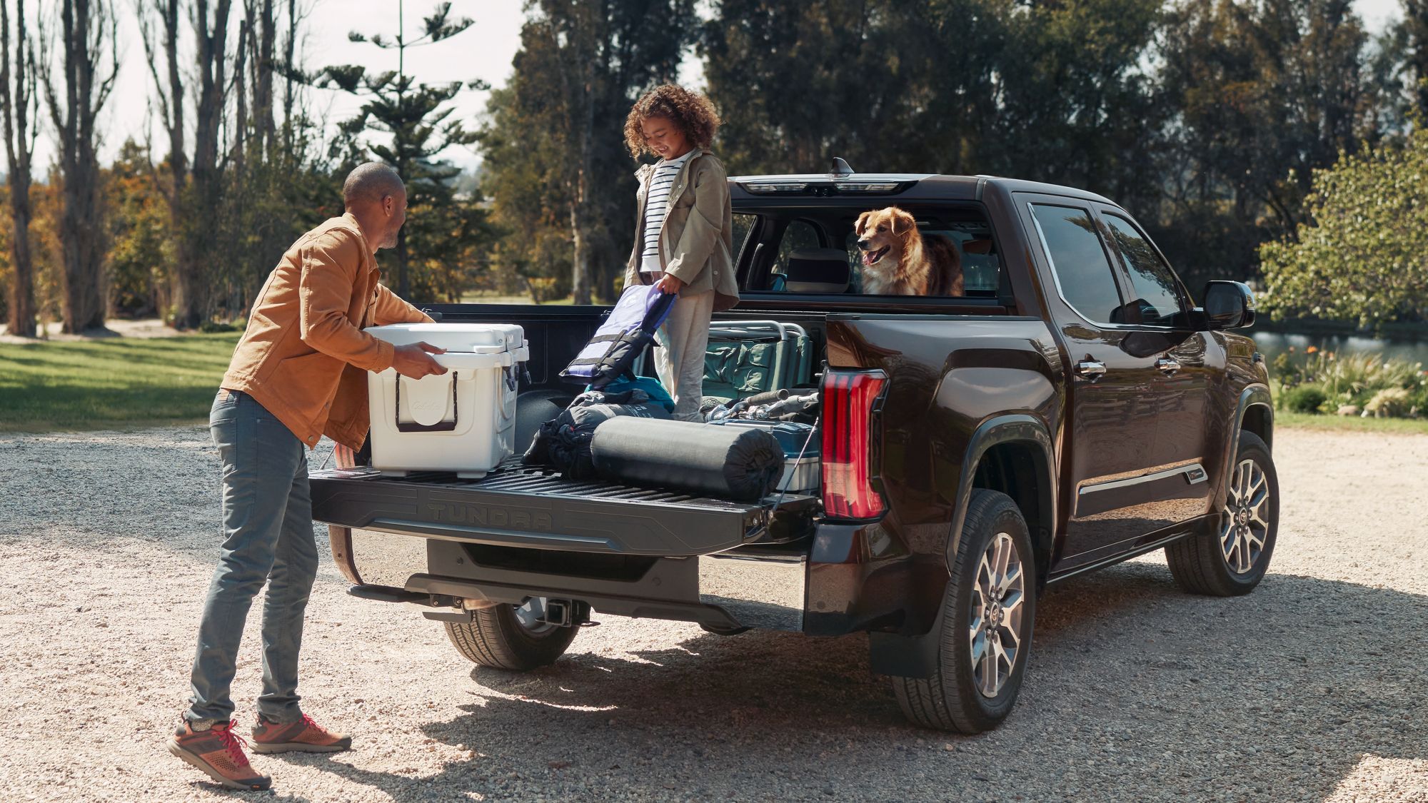 2025 Toyota Tundra i-FORCE MAX parked with dad and daughter unloading camping supplies from truck bed