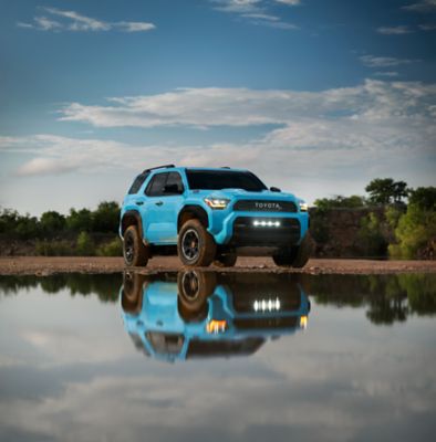 Toyota 4Runner parked beside a still lake