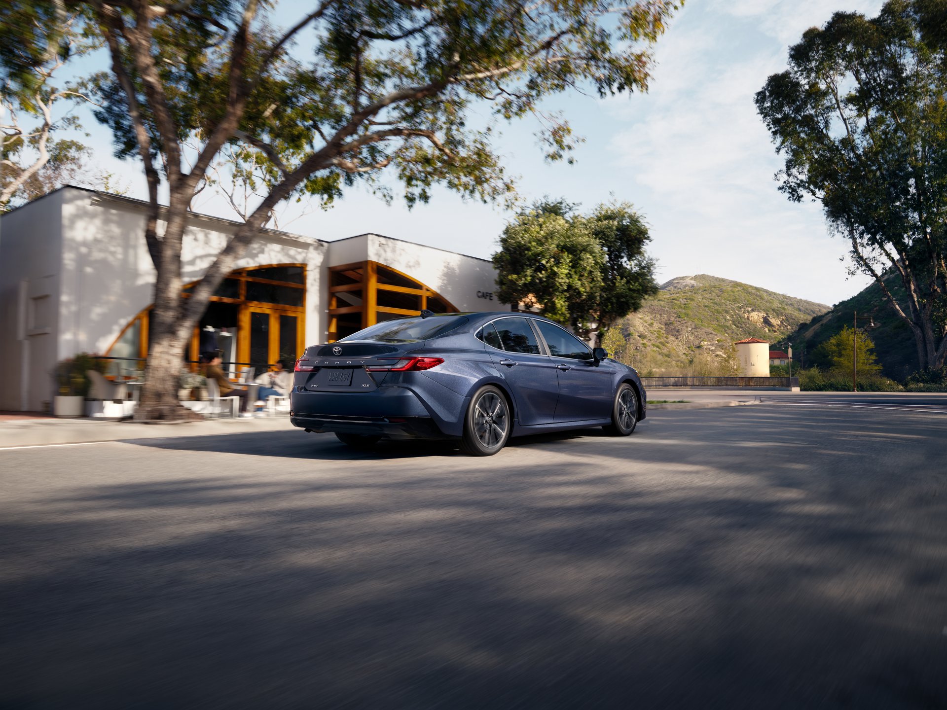Illustrative: a dark blue Toyota Camry sedan parked on a sunny street