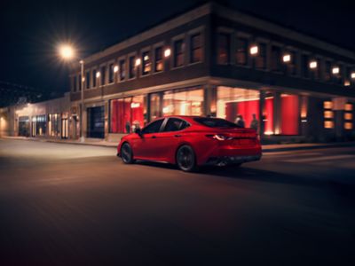Red Toyota Camry parked on a city street at night
