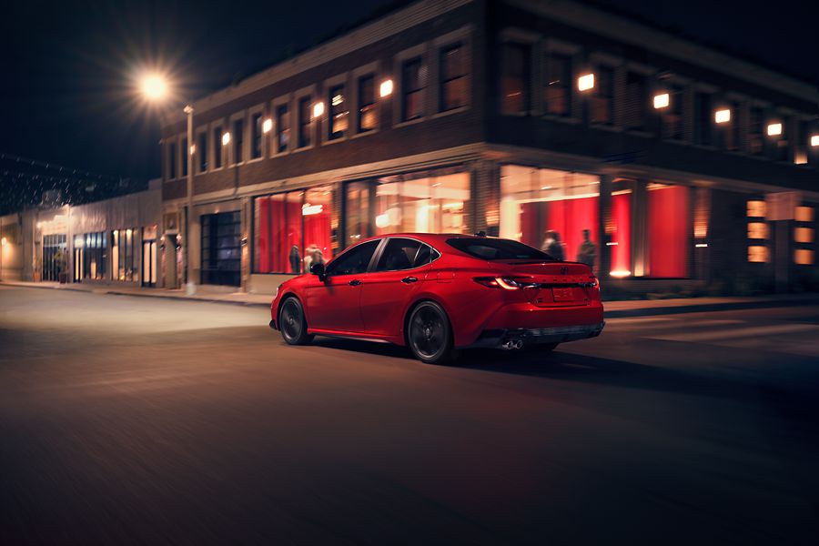 Red Toyota Camry parked on a city street at night