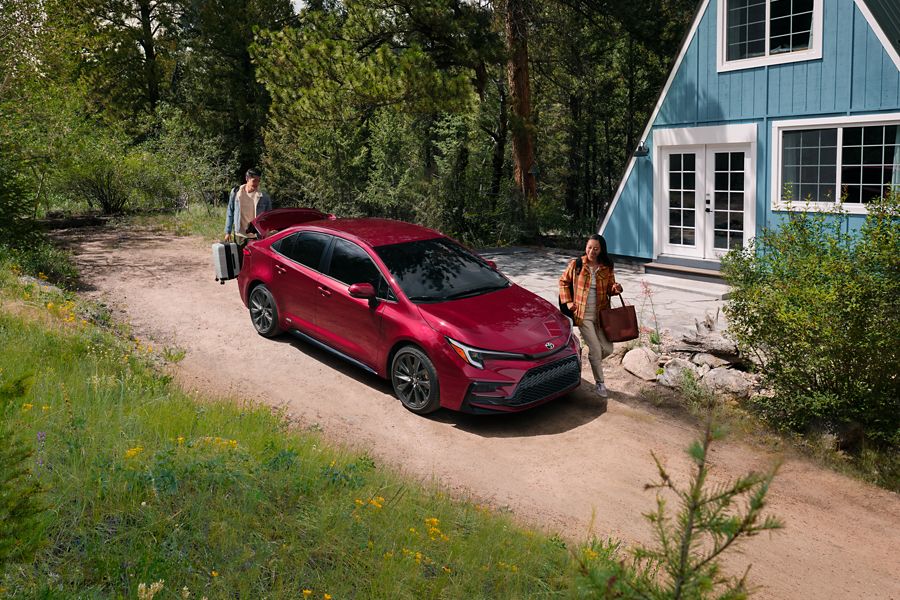Red Toyota Corolla parked outside a house