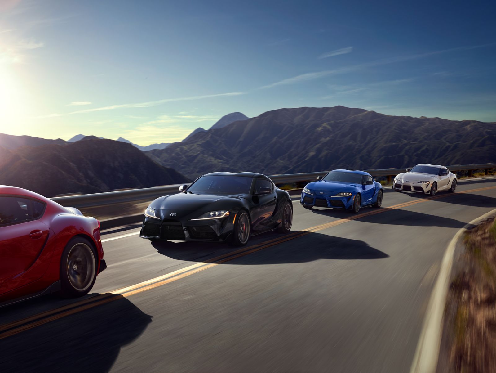 A group of Toyota GR Supras on a mountain road