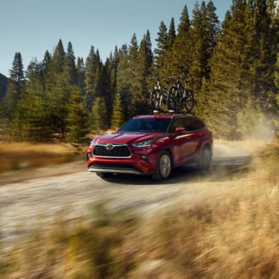 Red Toyota Highlander on a dirt road