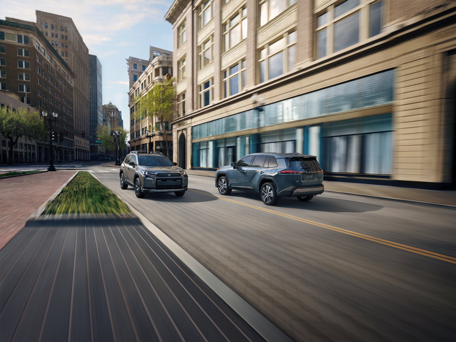 Illustrative: two Toyota RAV4 SUVs driving down a downtown street