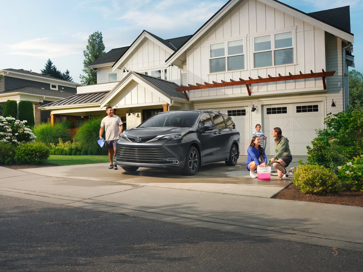 Family in their driveway with a Toyota Sienna
