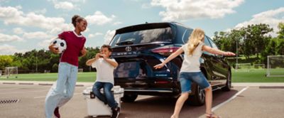 Family playing beside a Toyota Sienna