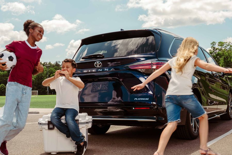 Family playing beside a Toyota Sienna